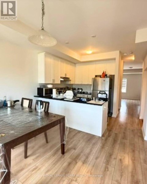 A kitchen with a wooden table and a white fridge.