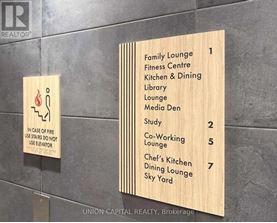 A wooden sign lists the locations of the lounges and studys in a building.