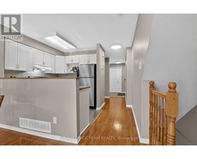 A kitchen with white cabinets and a wooden floor.