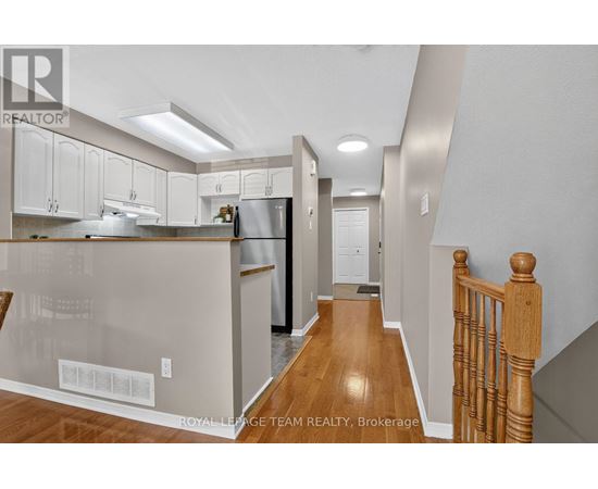 A kitchen with white cabinets and a wooden floor.