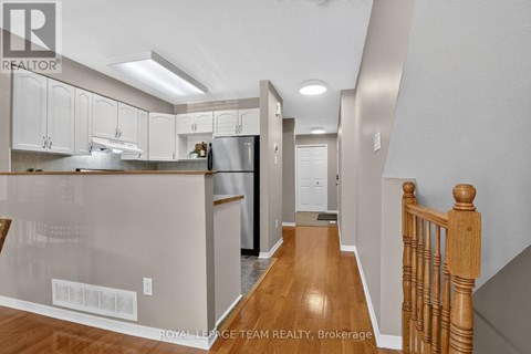 A kitchen with white cabinets and a wooden floor.