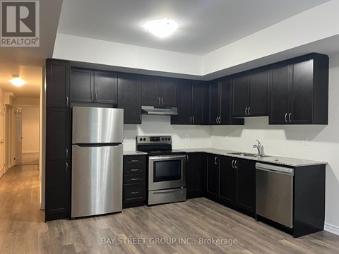 A kitchen with black cabinets and stainless steel appliances.