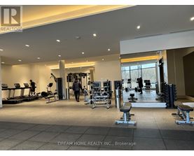 A gym with a variety of equipment including treadmills, weights, and exercise machines.
