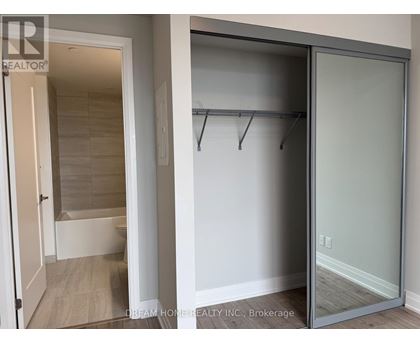 A glass door closet with a white door and a white wall.