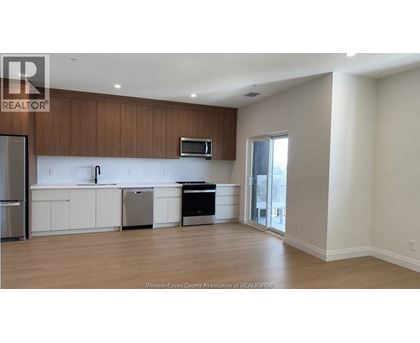 A kitchen with white cabinets and a black dishwasher.