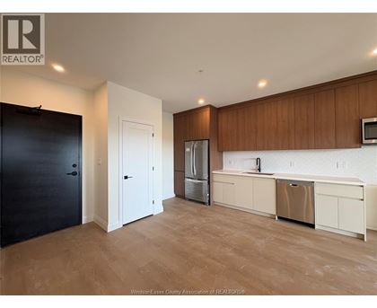 A kitchen with wooden cabinets and a refrigerator.