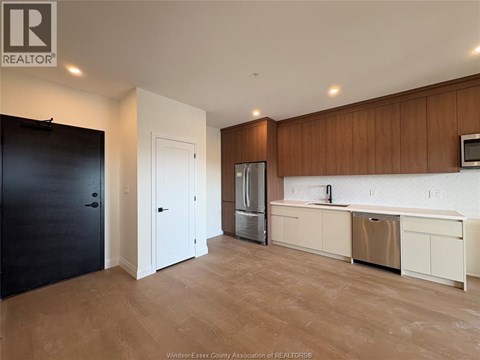A kitchen with wooden cabinets and a refrigerator.