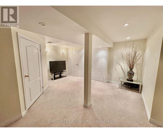 A living room with a television and a vase with branches in it.