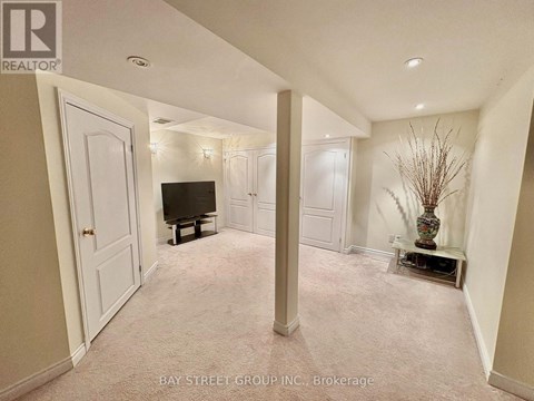 A living room with a television and a vase with branches in it.