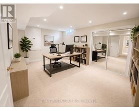 A well-lit office space with a desk, chairs, and bookshelves.