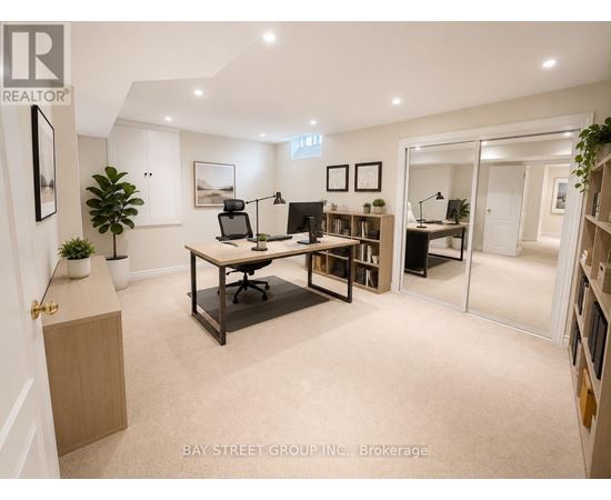 A well-lit office space with a desk, chairs, and bookshelves.