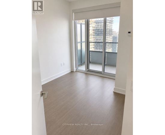 A room with a sliding glass door leading to a balcony.