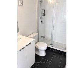 A white toilet in a bathroom with a glass shower door.