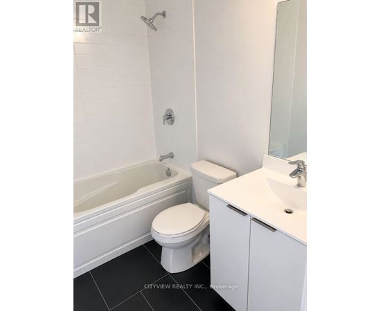 A white toilet sits next to a white sink in a bathroom.