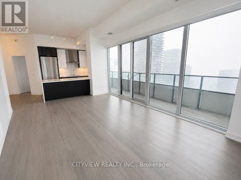 A spacious room with a bar area and large windows.
