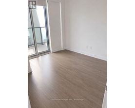 A room with a wooden floor and a sliding glass door.