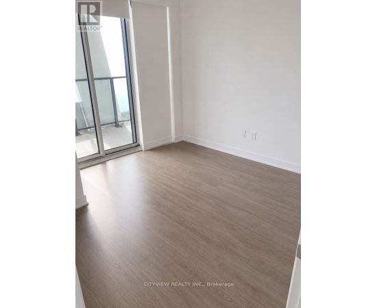 A room with a wooden floor and a sliding glass door.