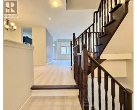 A staircase with a wooden banister and a white wall on the left side.