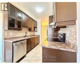 A kitchen with brown cabinets and granite countertops.