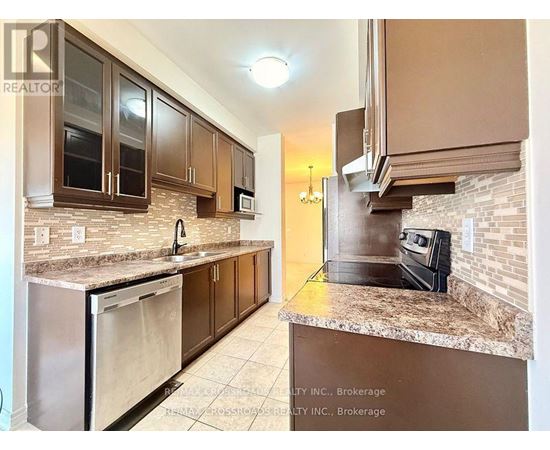 A kitchen with brown cabinets and granite countertops.