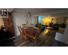 A dining room with a wooden table and chairs.