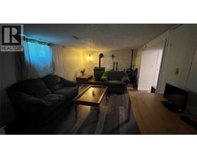 A living room with a couch, coffee table, and television.