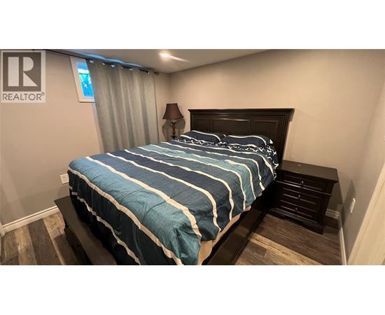 A bed with a blue and white striped comforter in a bedroom.