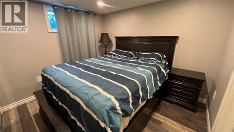 A bed with a blue and white striped comforter in a bedroom.