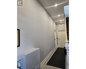 A hallway with a staircase and a door.