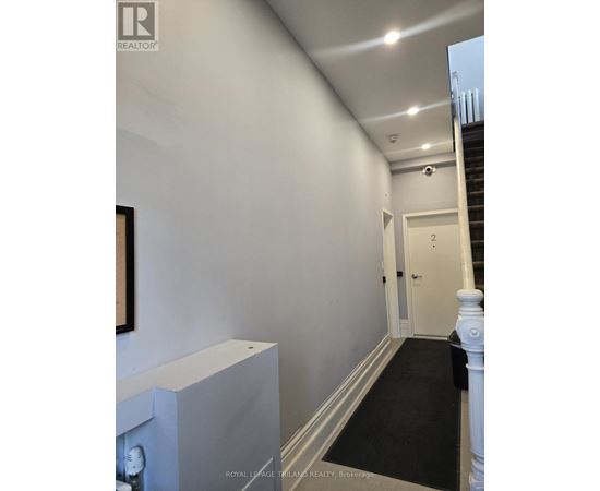 A hallway with a staircase and a door.