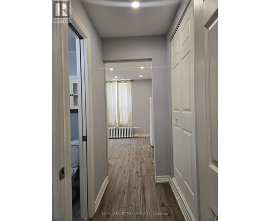 A hallway with white doors and a wooden floor.
