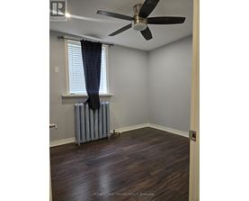 A room with a ceiling fan and a radiator on the floor.