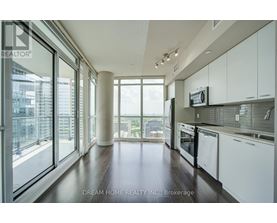 A modern kitchen with white cabinets and a view of the city.