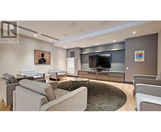 A modern living room with a grey couch and a television.