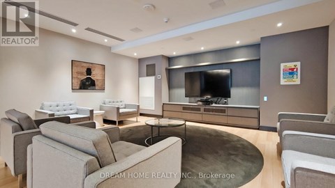 A modern living room with a grey couch and a television.