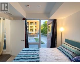 A bedroom with a bed and a window overlooking a street.
