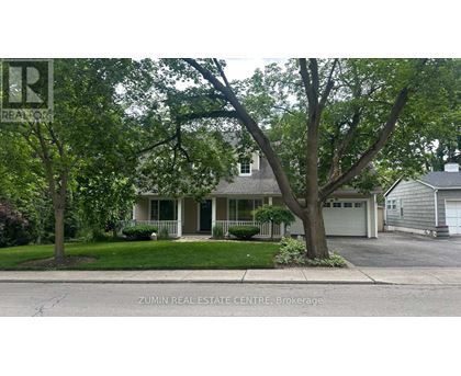 A house with a green tree in front of it.