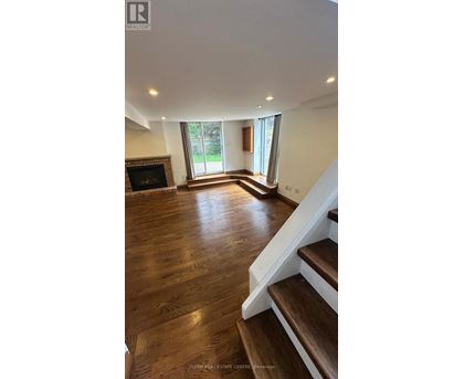 A living room with a fireplace and wooden floors.