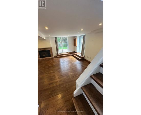 A living room with a fireplace and wooden floors.