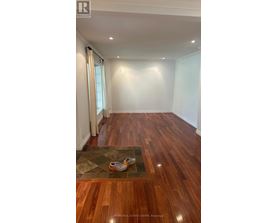 A room with wooden floors and a rug with shoes on it.