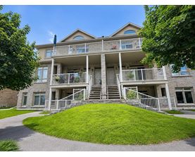 A large house with a balcony and stairs leading to the front door.