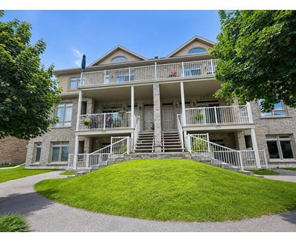 A large house with a balcony and stairs leading to the front door.