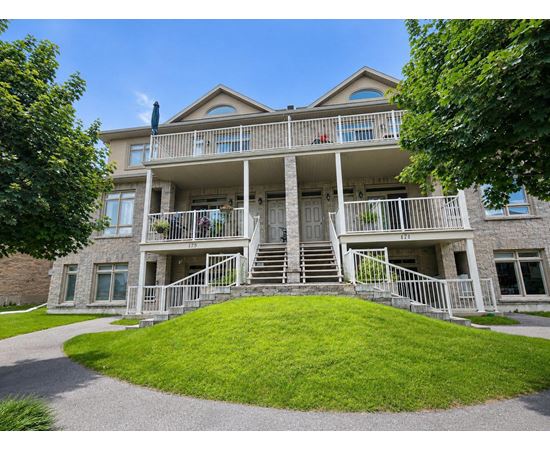 A large house with a balcony and stairs leading to the front door.