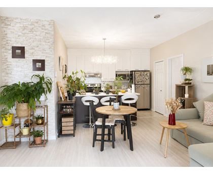 A kitchen with a dining table and chairs in the middle of the room.