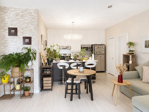 A kitchen with a dining table and chairs in the middle of the room.