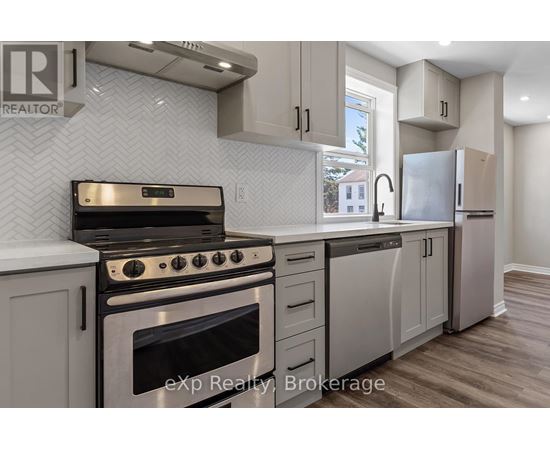 A modern kitchen with a stove top oven and a refrigerator.