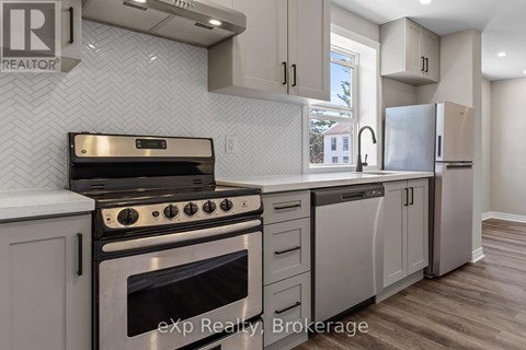 A modern kitchen with a stove top oven and a refrigerator.