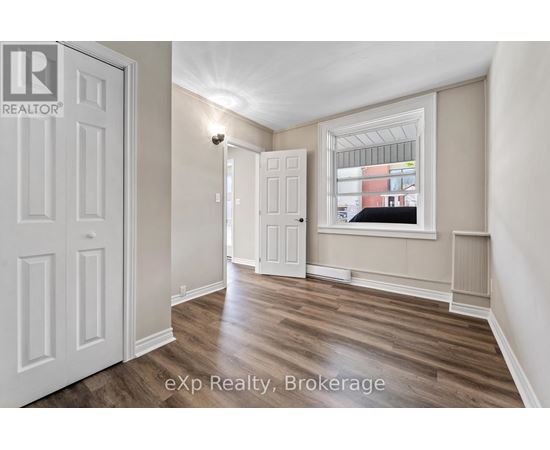 A room with a white door and a window with a view of a building outside.