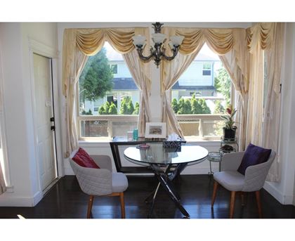 A dining room with a table and chairs.