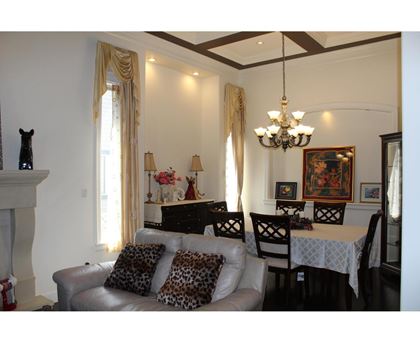 A living room with a grey couch and a chandelier.